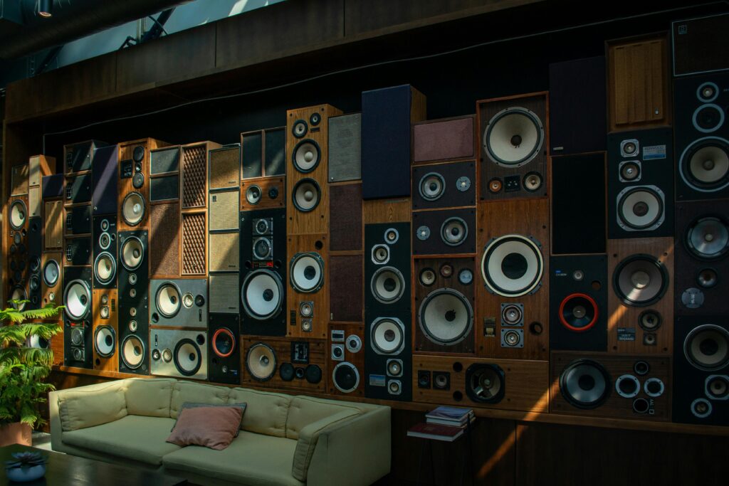 A cozy living room with a striking wall of vintage speakers, showcasing retro audio aesthetics and comfortable seating.